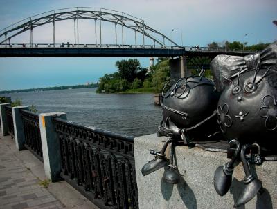 Уличные скульптуры на фоне моста в парке Шевченко в Днепре